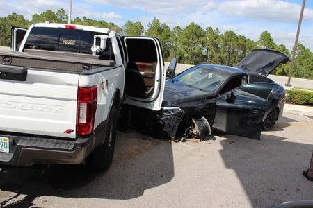 Picture of suspects car crashed into pick up truck showing the front wheel missing