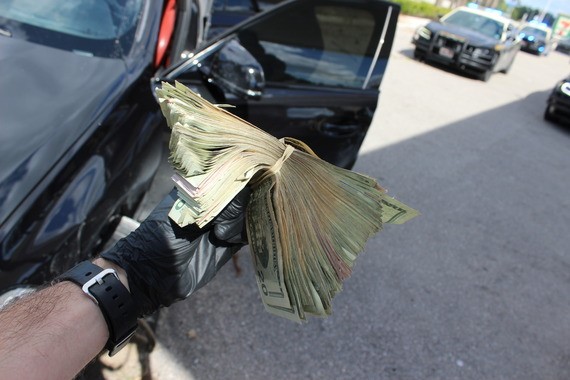 Montón de dinero en efectivo muy grande encontrado en el auto del sospechoso